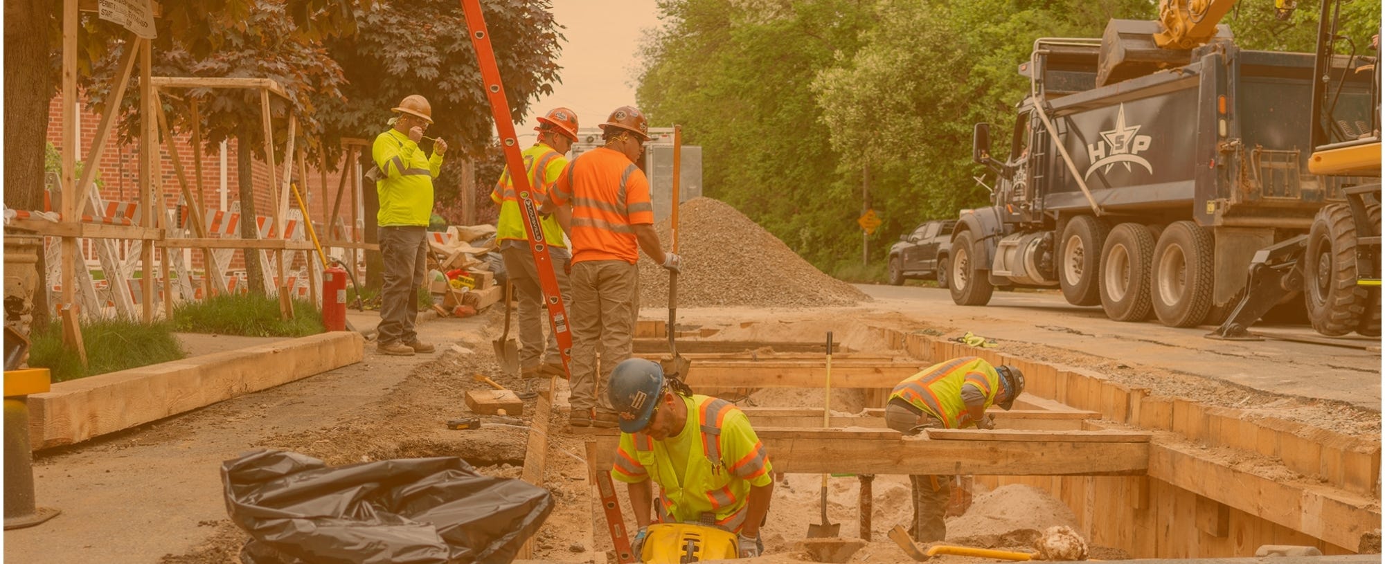 Construction workers in and next to a trench