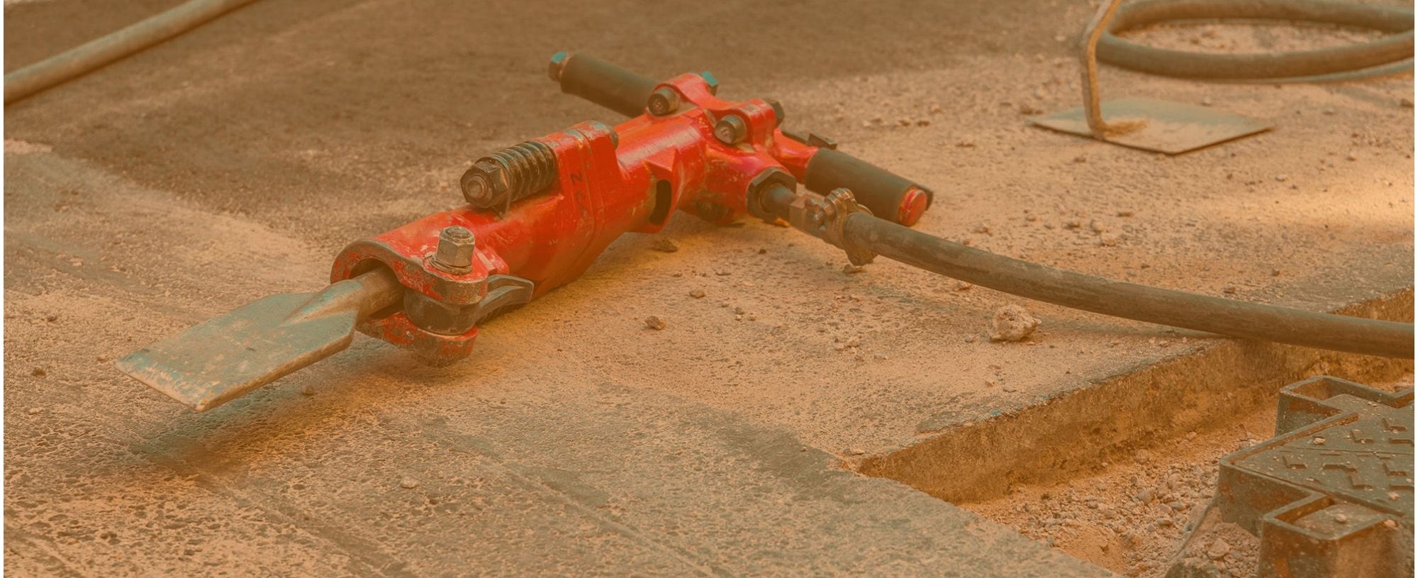Jackhammer laying on the ground at a construction site