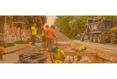 Construction workers in and next to a trench